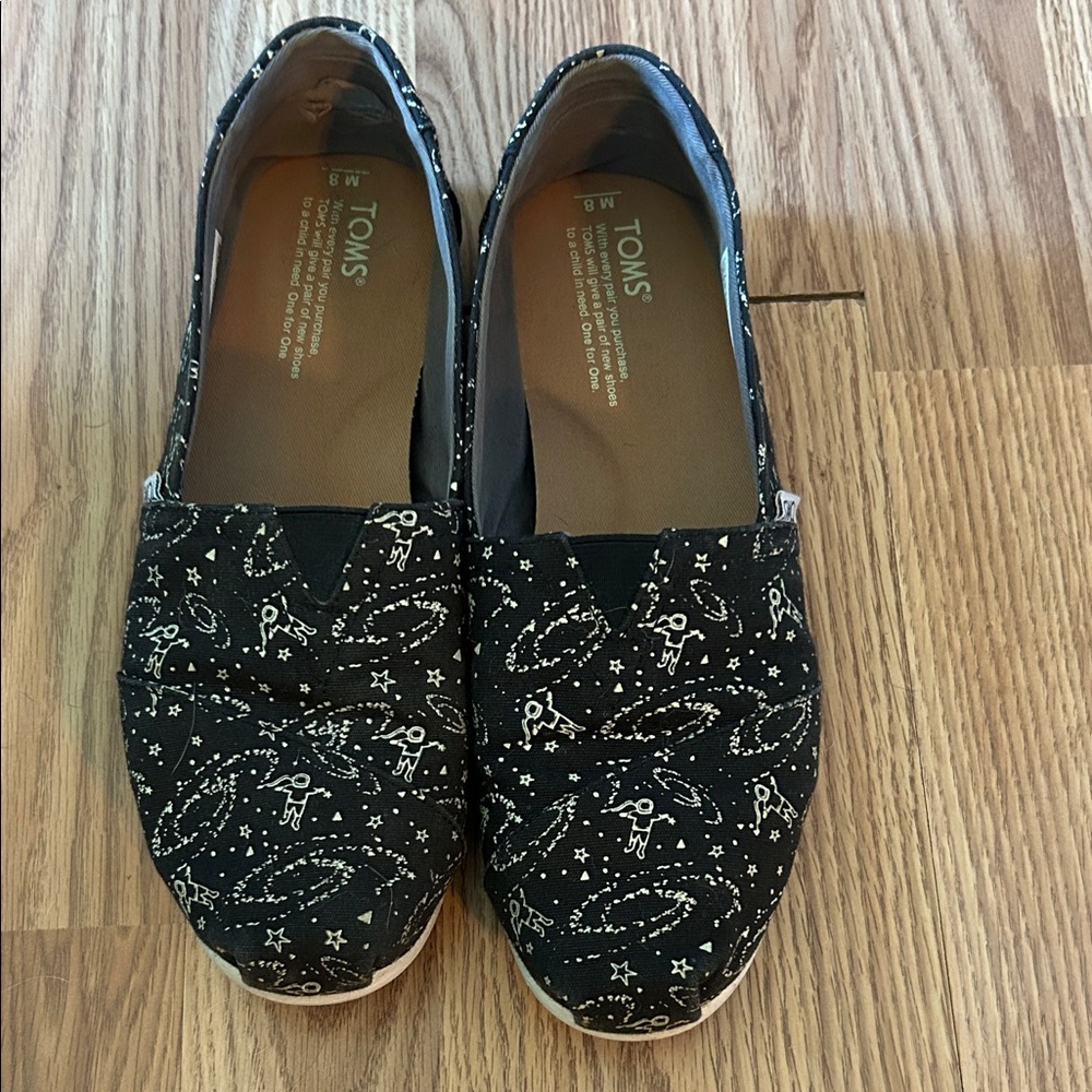 TOMS Black Slip-Ons with White Astronaut Design